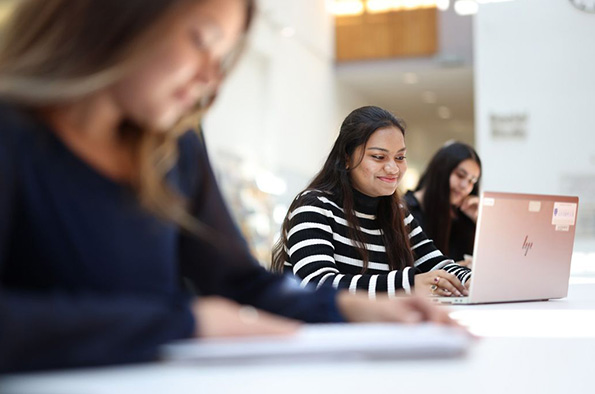 Students studying, with one student looking at a laptop
