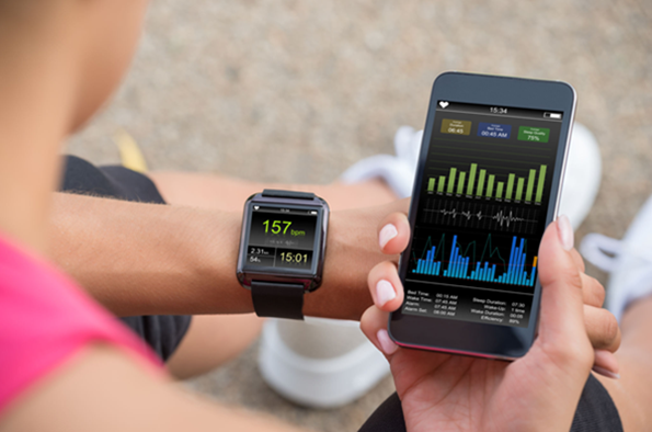 womens wrist with a smart watch and mobile phone dsiplay fitness tracking data